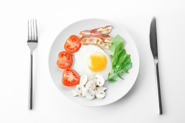 Plate with tasty egg for breakfast on white background