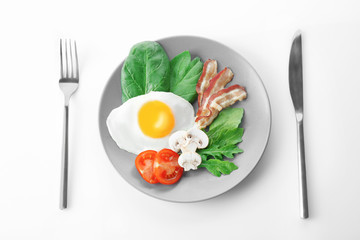 Plate with tasty egg for breakfast on white background