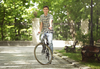 Naklejka premium Young handsome man with bicycle outdoors on sunny day