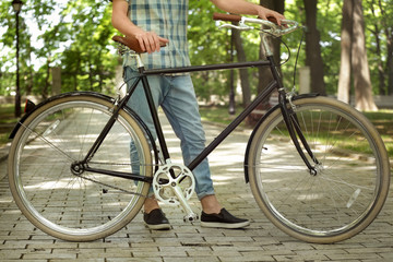 Fototapeta premium Young handsome man with bicycle outdoors on sunny day