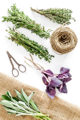 Obraz premium fresh herbs and greenery for spices and cooking on white desk background top view