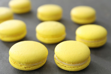 Tasty homemade lemon macarons on table