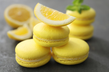 Tasty homemade lemon macarons on table