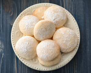 Plate with homemade lemon cookies on wooden table