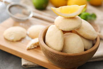 Bowl with homemade lemon cookies on wooden board
