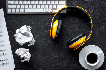 dj work set with blank paper for notes, headphones on dark background top view