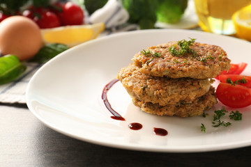 Broccoli pancakes served with cherry tomato and sauce on white plate, closeup