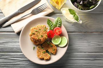 Broccoli pancakes served with lime slices, cherry tomato and basil leaves on plate