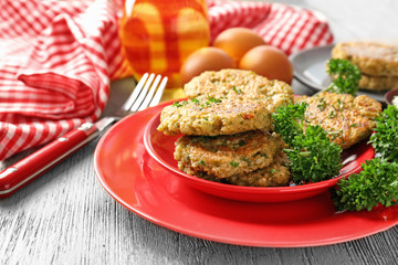 Broccoli pancakes served with fresh parsley on red plate