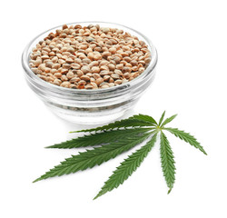 Bowl with hemp seeds on white background