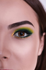 Young beautiful woman with fancy green makeup, closeup