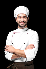 Young male chef on black background