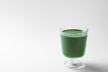 Glass of fresh green smoothie on white background