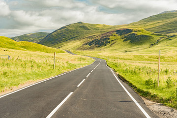 Fototapeta na wymiar roads on violet heath blossom hills in the Highland of Scotland in England