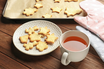 Christmas cookies and cup of tea on wooden table