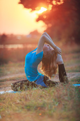 beautiful woman doing yoga outdoors On green grass