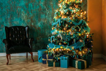 Green New Year tree decorated with toys and balls. Christmas background with grunge plaster wall