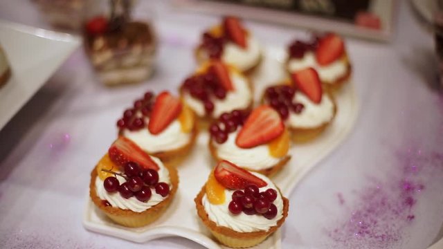 Capkake with a slice of strawberry and currant berries.