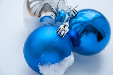 Blue Christmas balls in the snow on a white background