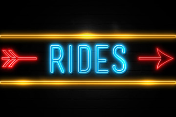 Rides  - fluorescent Neon Sign on brickwall Front view