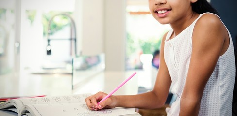 Portrait of girl drawing in book