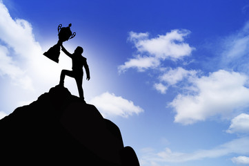 Silhouette people show trophyl on top of mountain, concept as winner and success in business