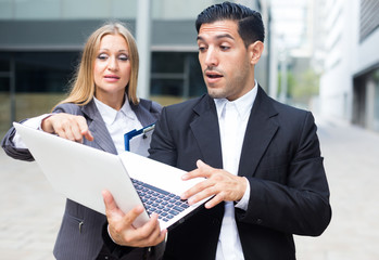 Businessman with his woman partner are looking project on laptop