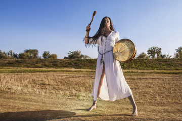 Shaman woman  drumming  away