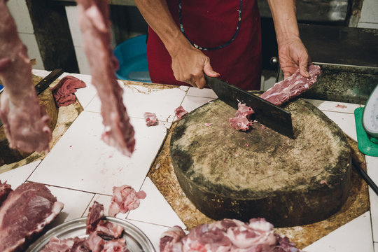 Butcher with a Cleaver chopping Pork Ribs