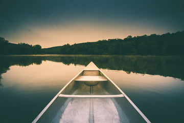 Aluminum canoe on a mountain lake upstate New York. Camping. outdoors and adventure concept.  Faded, vintage color post processed