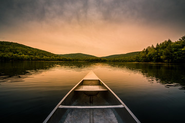 Aluminum canoe on a mountain lake upstate New York. Camping. outdoors and adventure concept. ...