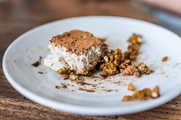 Closeup of homemade tiramisu cake on plate on kitchen room table showing detail and texture