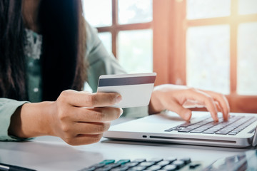 Hipster woman hands holding laptop and using credit card for online shopping.Online shopping concept.