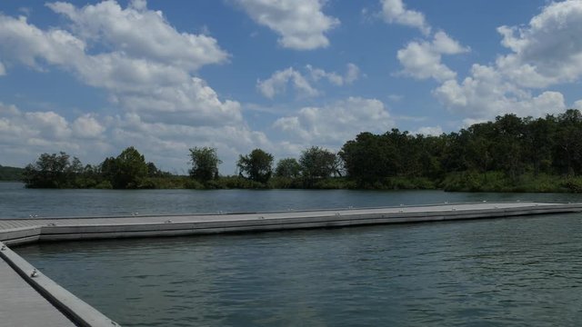 Wide shot of a lake with a floating jetty extending into the water