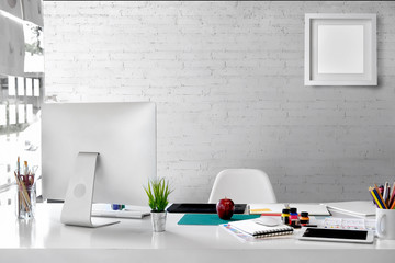 Stylish workspace with desktop computer, office supplies, houseplant and books at home or studio....