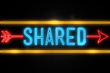Shared  - fluorescent Neon Sign on brickwall Front view