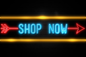 Shop Now  - fluorescent Neon Sign on brickwall Front view