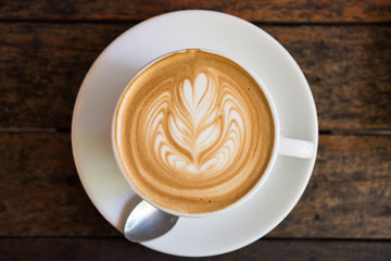 A Cup of hot latte art coffee on wooden table