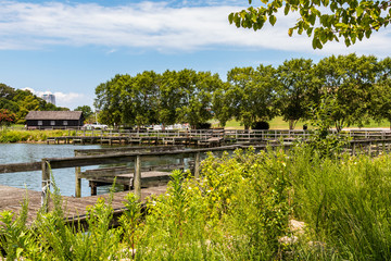 Fototapeta premium Trees surround the boat dock on Lake Trashmore, one of two lakes at Mount Trashmore Park, a former landfill in Virginia Beach, Virginia, which was converted to a city park in 1974. 