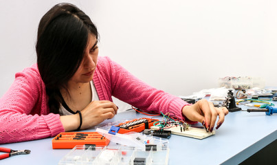 Young electronics student learning about basic PCB connection and robotics