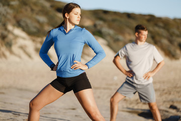 Young couple on beach training together