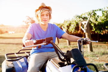 Obraz premium Boy riding farm truck in vineyard