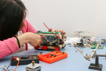 Young electronics student learning about basic PCB connection and robotics