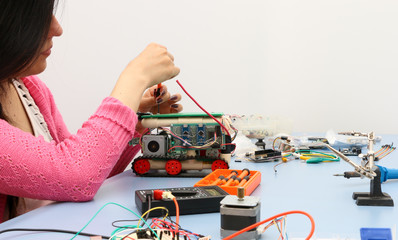 Young electronics student learning about basic PCB connection and robotics