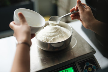 Bakery chef weighing flour on the digital scale