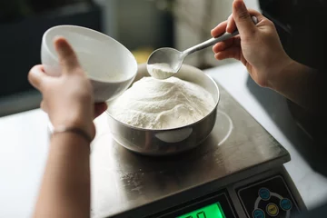 Badkamer foto achterwand Bakery chef weighing flour on the digital scale © makistock