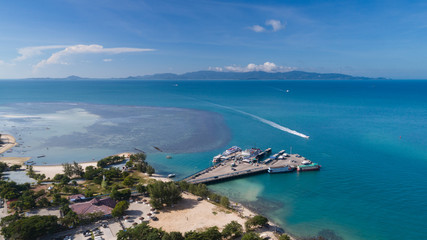 Naklejka na ściany i meble Aerial view of Koh Phangan international port with boats in the clear blue sea