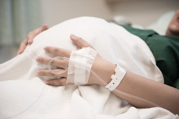 hand of Woman patient admitted to the hospital with saline intravenous (iv)