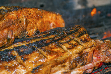 Obraz na płótnie Canvas pork ribs marinated grilling on hot burning charcoal barbecue close-up