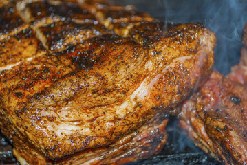 pork ribs marinated grilling on hot burning charcoal barbecue close-up